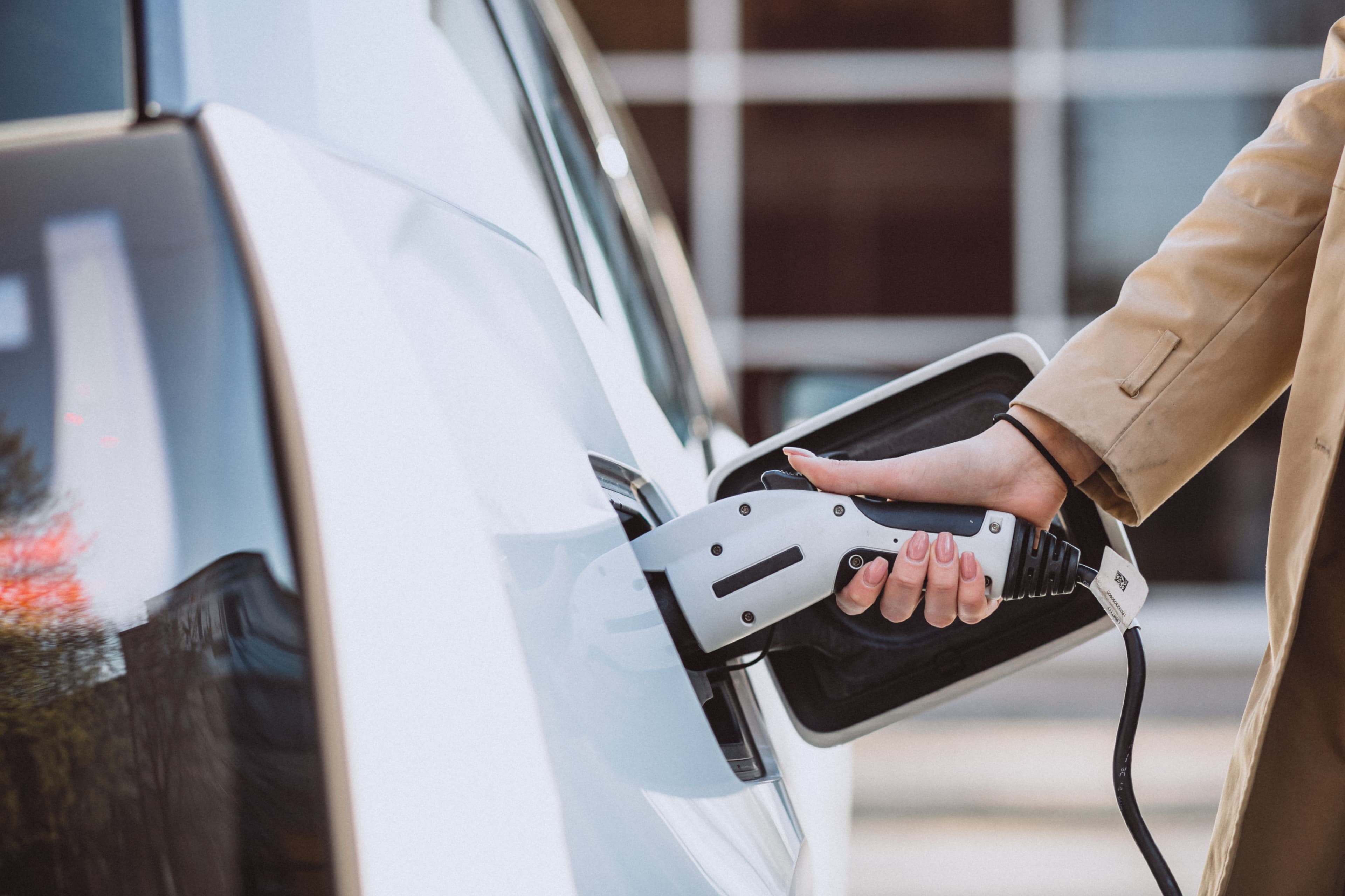 White vehicle being charged with a charge cable