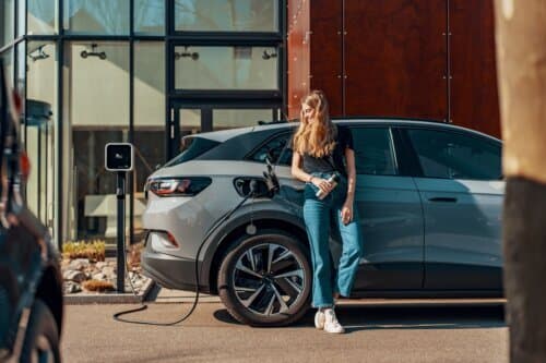 Woman charging a grey car