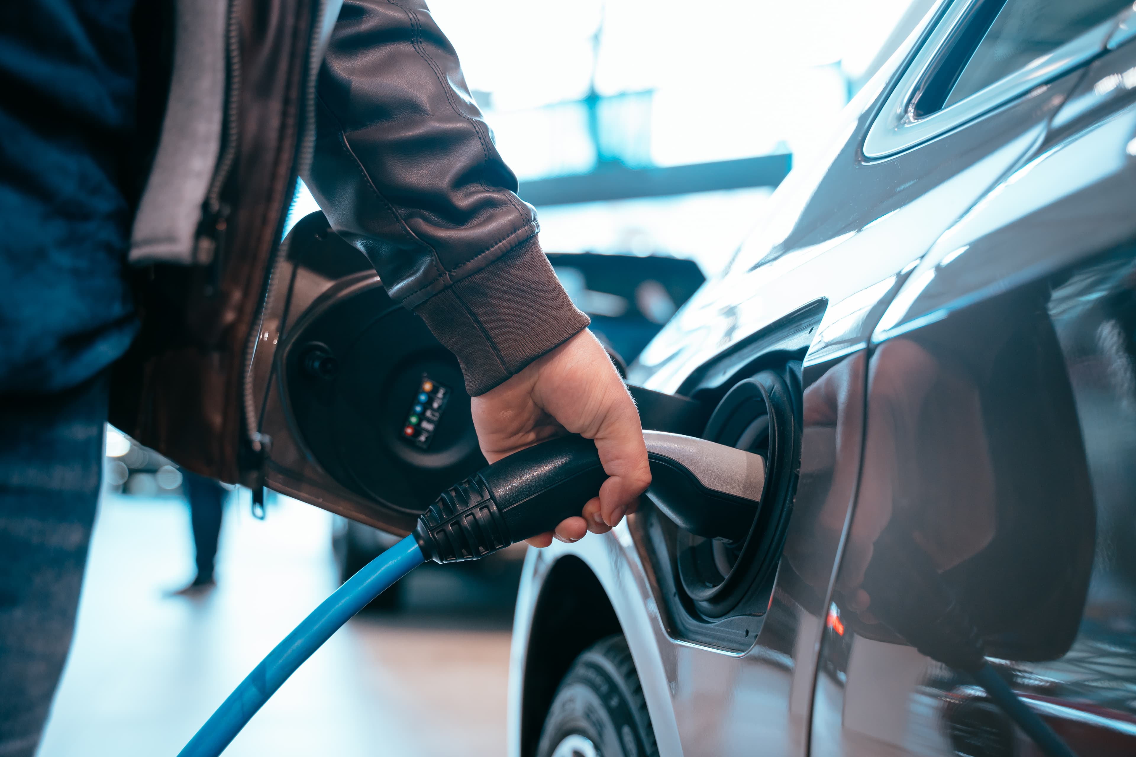 A blue charging cable used to charge a car