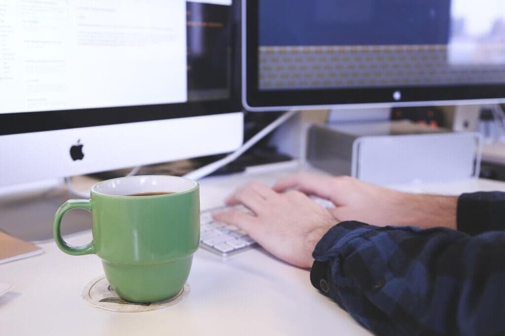 A person typing on a keyboard in an office environment